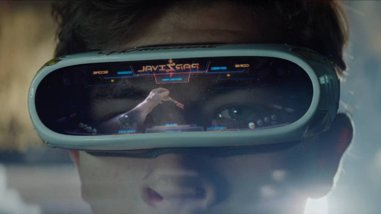 Still from the movie "Ready Player One" (2018). Close up of a teen male wearing a virtual reality headset. The view inside the headset is a hand reaching out for a key.