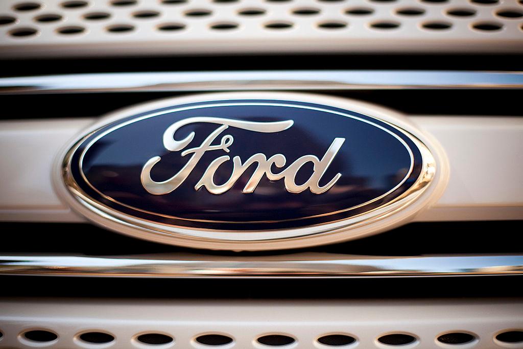 Close-up of a blue Ford emblem centered on a chrome vehicle grille
