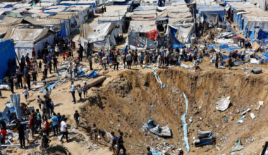 Palestinians inspect the site of an overnight Israeli strike on a medicine warehouse, in Deir al-Balah