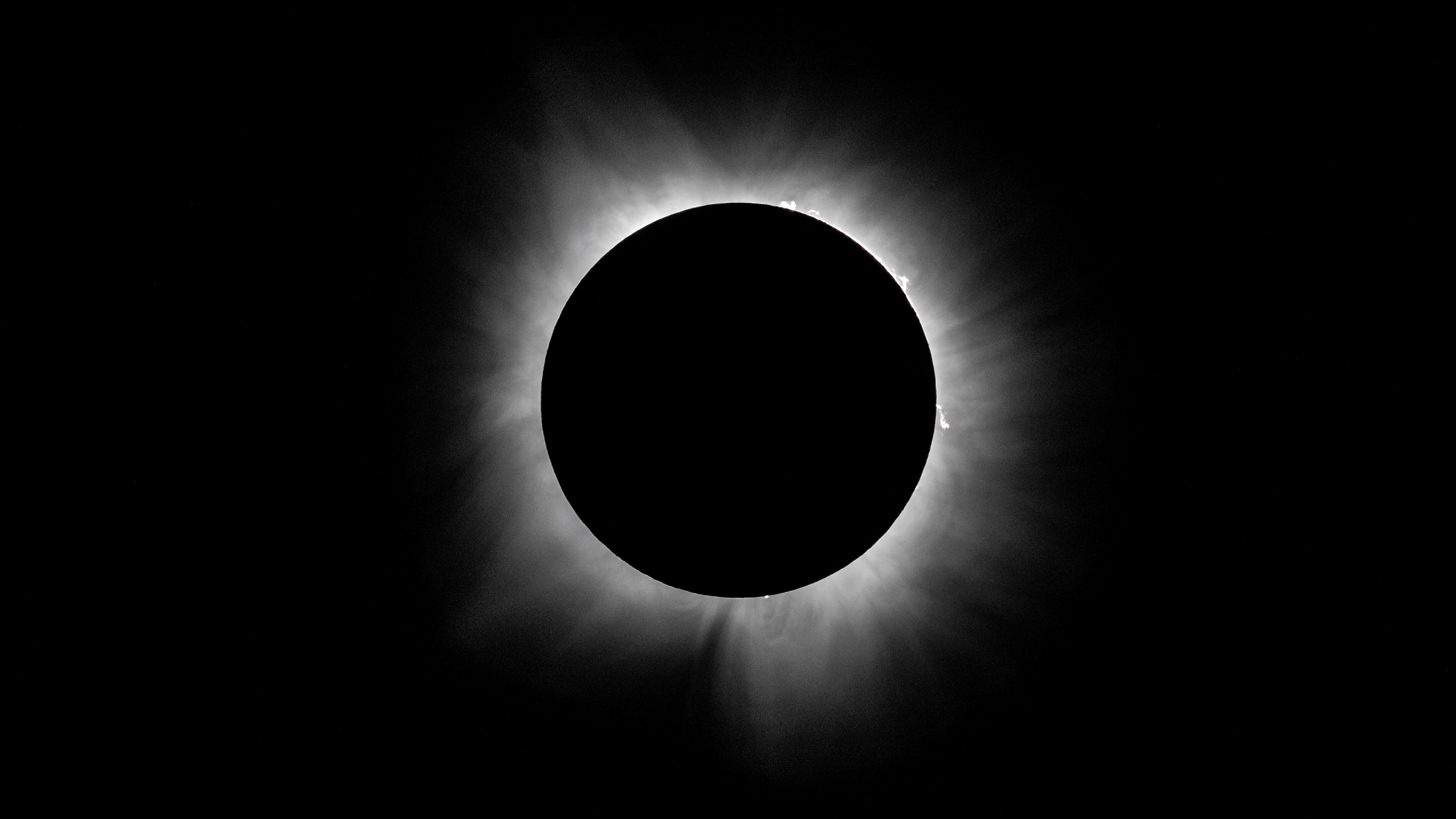 The sun's corona shines from behind the lunar disk in a black sky at totality during the 2024 eclipse.