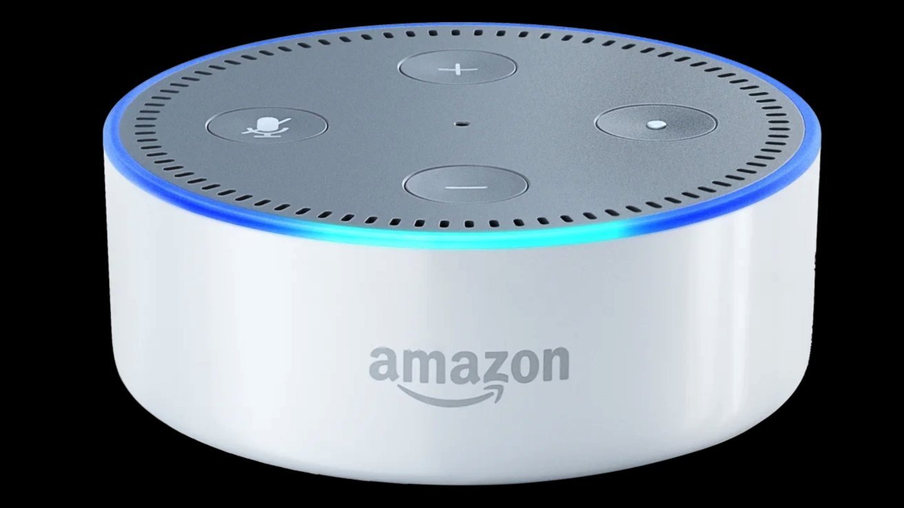 Small white Amazon Echo Dot smart speaker with gray top, four control buttons, and a glowing blue light ring, shown against a solid black background