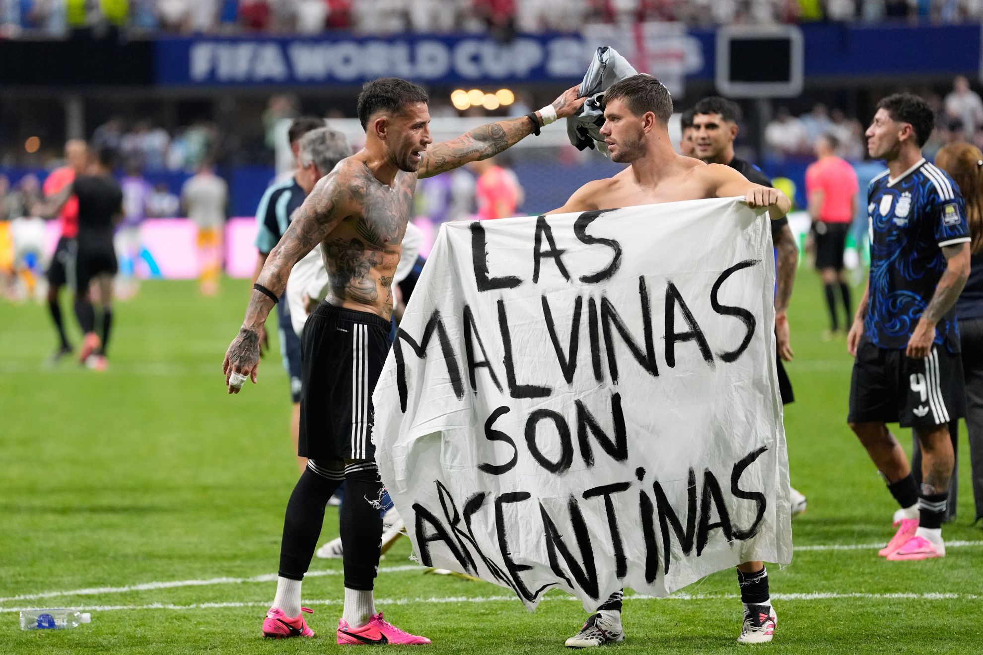 Argentina's Giovani Lo Celso holds a banner with the words "The Malvinas are Argentine", referring to the Falkland Islands, while teammate Argentina's Nicolas Otamendi gestures to him, at the end of the World Cup semifinal soccer match between England and Argentina in Atlanta, Wednesday, July 15, 2026.