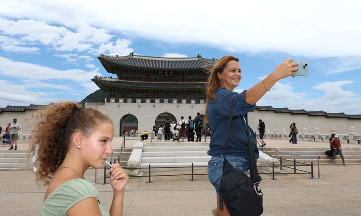 A foreign tourist takes a selfie in front of the Gyeongbok Palace in Seoul, Sunday. Yonhap