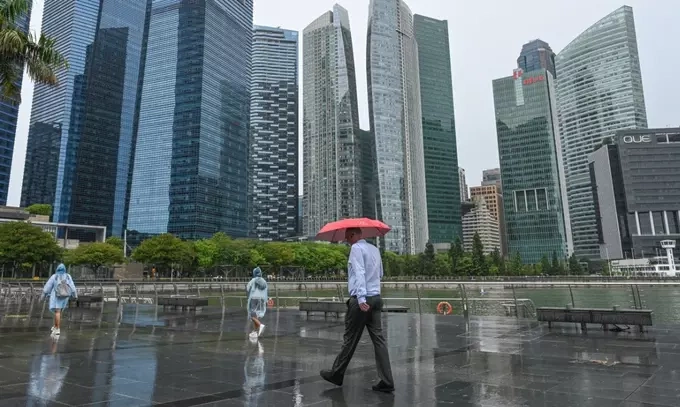 Pedestrians walk along the promenade near the financial business district in Singapore on October 14, 2024. Photo by AFP