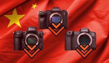 Three digital cameras are arranged in a triangle over a red flag with yellow stars, each featuring a downward-pointing orange chevron.