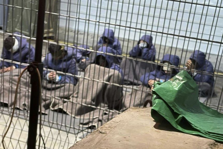 This 2024 photo provided by Breaking The Silence, a whistleblower group of former Israeli soldiers, shows prisoners with their hands and legs restrained in the yard at the Sde Teiman military prison in southern Israel.