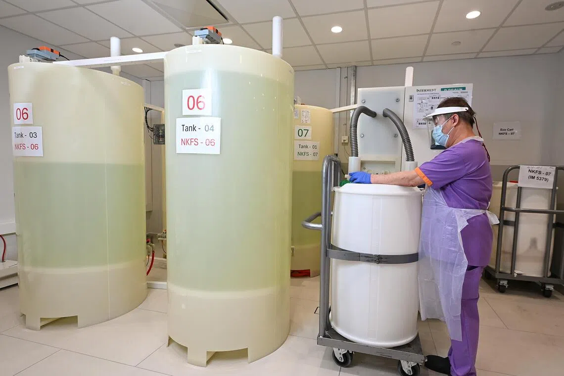 Dialysis care associate Tien Wee Hock transfers the acid concentrate from a bulk drum into the central holding tanks of CDS. The system then automatically pipes the acid directly to every dialysis chair in the centre, through a closed loop.