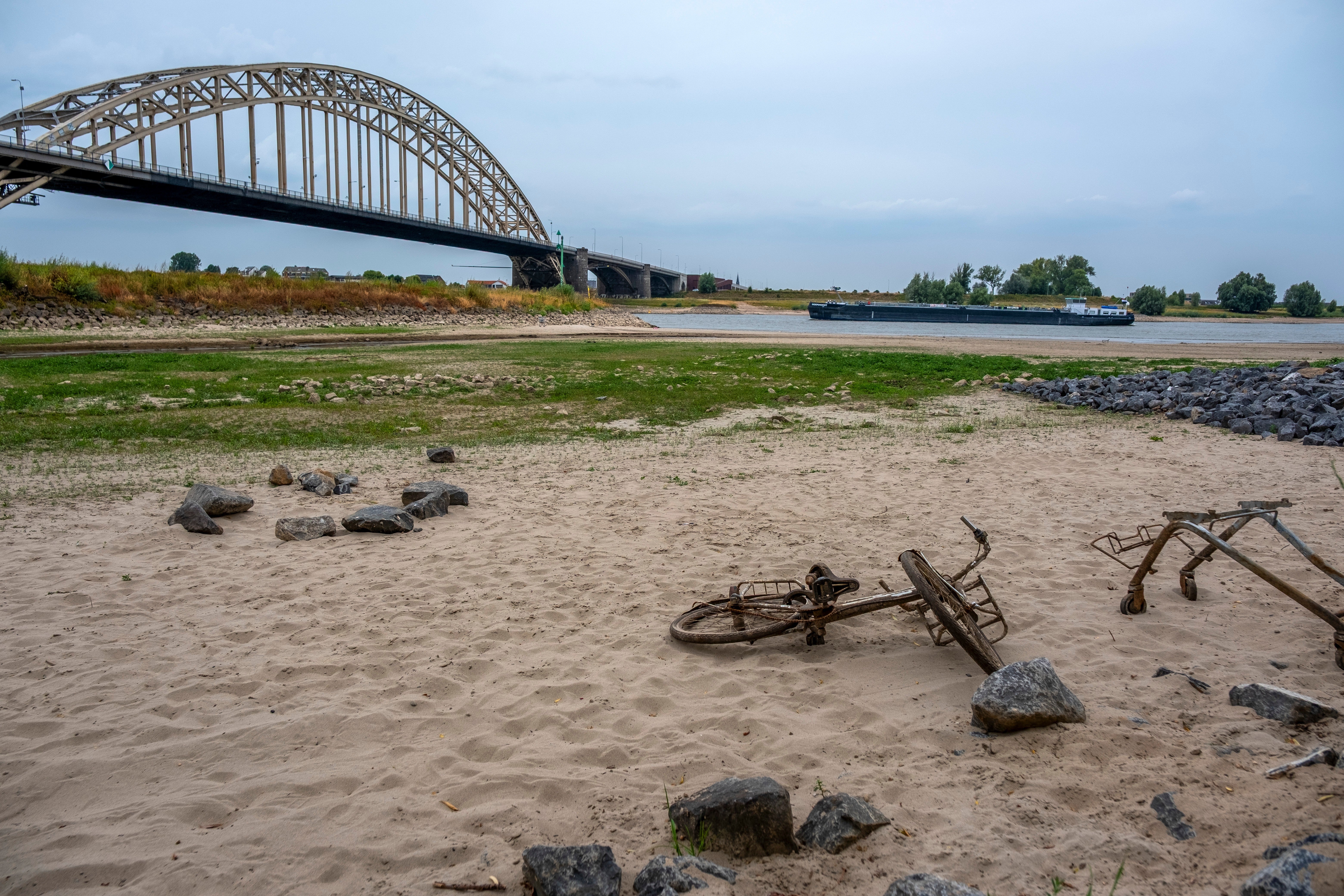 A rusty bicycle and shopping cart are exposed as the Slinge river recedes in Varsseveld, Netherlands