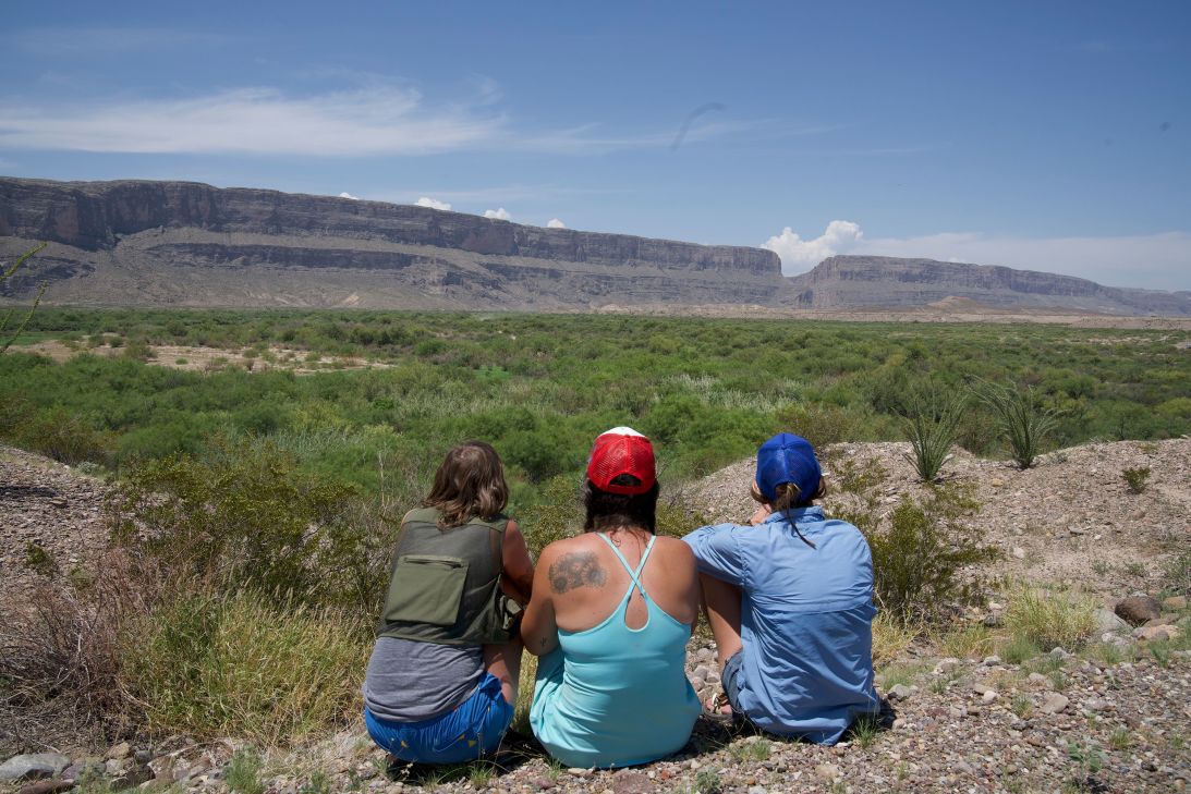 A group of local residents tearfully watch bulldozers go to work deep in the brush near the Rio Grande in Big Bend National Park.