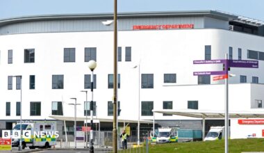 A large white building with ambulances parked outside