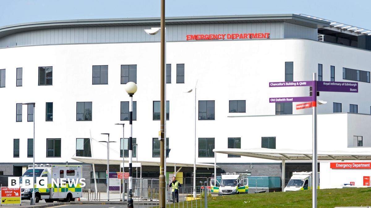 A large white building with ambulances parked outside