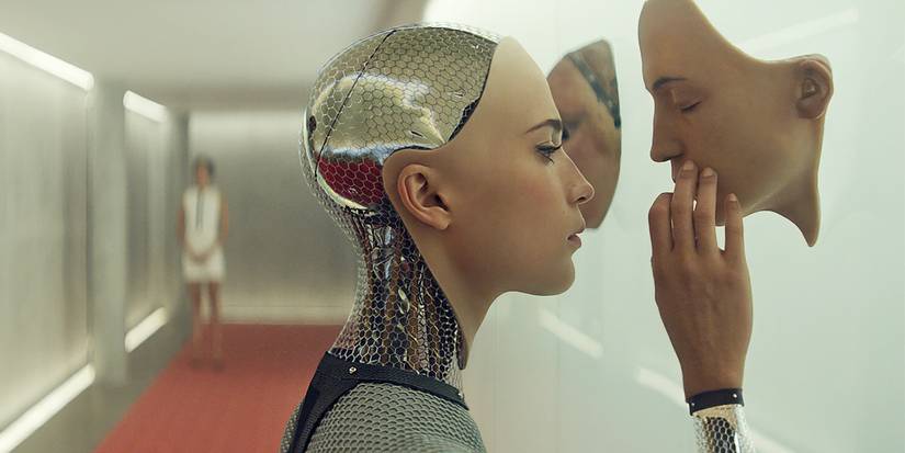 Alicia Vikander as Ava looking at human faces on a wall in Ex-Machina
