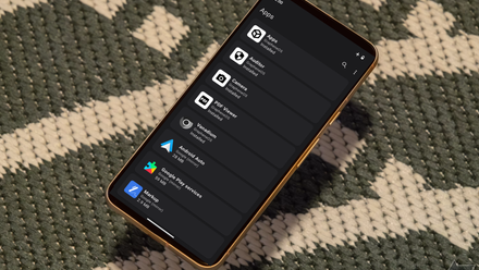 A Pixel 8 with the GrapheneOS Settings Menu sits atop a green and white textile