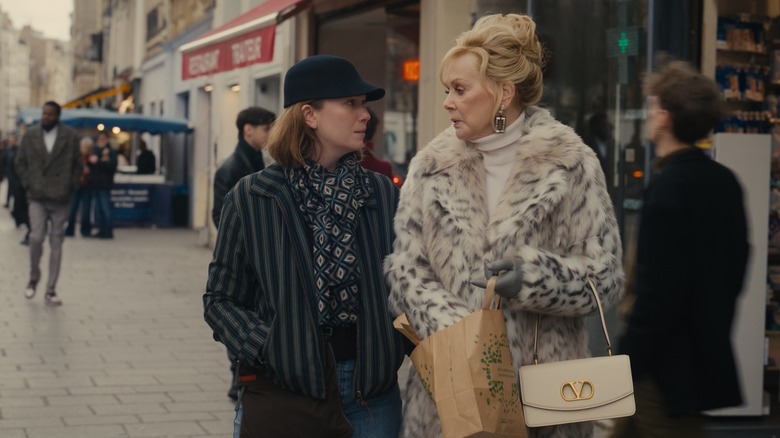 Hannah Einbinder and Jean Smart stand on a busy street in Paris as their characters on 