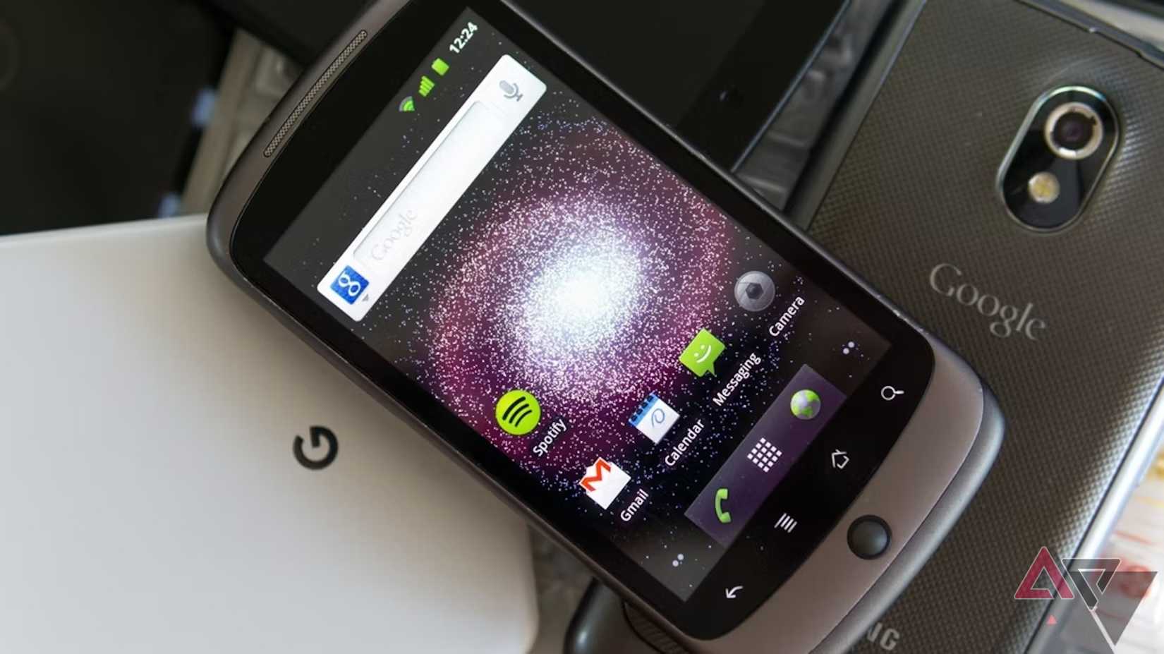 A Google Nexus One laying on top of several other smartphones.