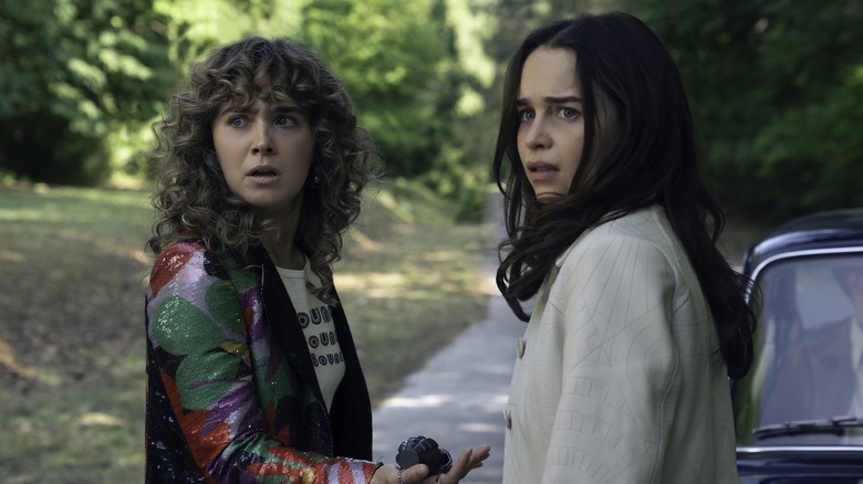 Bea and Twila standing on a road next to a car in 