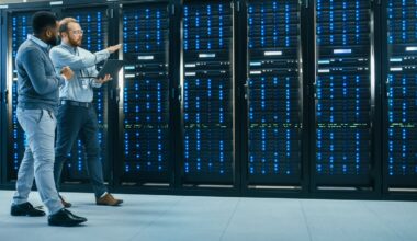 Two computer technicians are walking through a data center.