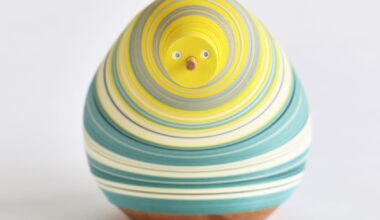 a small paper figure made from numerous layers of colored paper on a flexible central axis so that it looks like an anthropomorphized pear