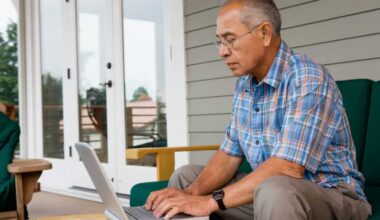 Retiree using a laptop outside his house.