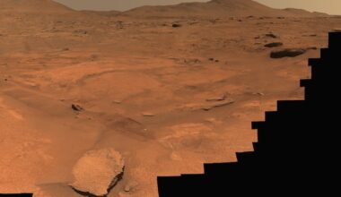 Water systems on early Mars: Reddish brown rocky terrain, with 2 areas heavily blacked out.