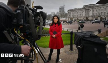 Maryam Moshiri stand in a black coat. The Vatican is in the background