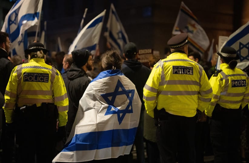A woman draped in an Israeli flag stands next to police officers as she joins members of the Jewish community outside BBC Broadcasting House to demonstrate against the BBC's ongoing refusal to label Hamas as terrorists, in London, England, October 16, 2023; file photo.