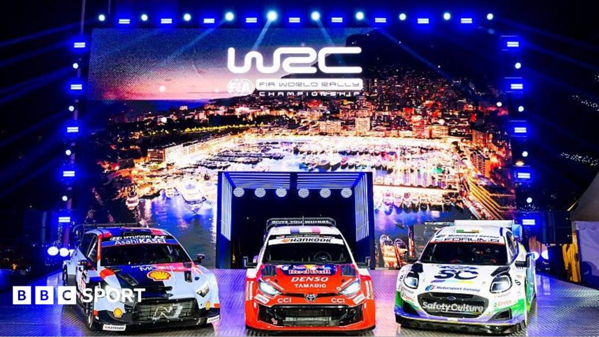 Three rally cars in front of a lit up sign featuring the World Rally Championship logo