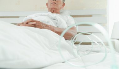 Older patient receiving oxygen in a hospital bed during treatment for sepsis.
