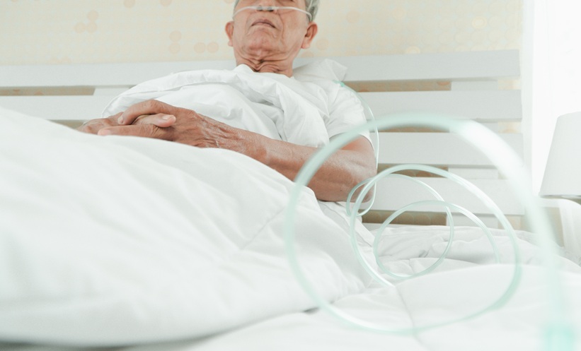 Older patient receiving oxygen in a hospital bed during treatment for sepsis.