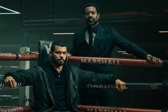 Fightland Nicholas Pinnock standing outside the ring and leaning on the ropes, with Howard Charles sitting on a stool.