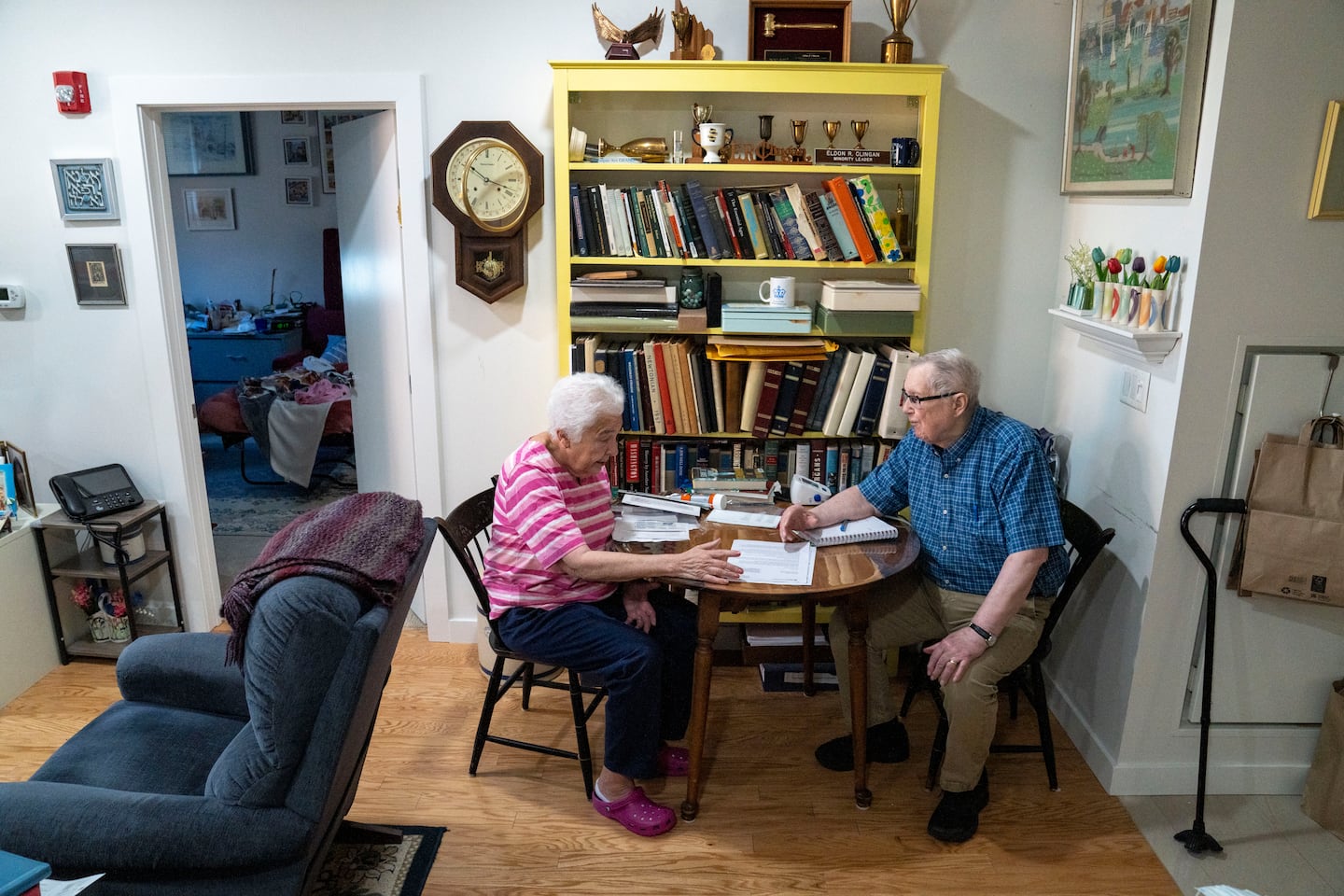 Carol and Eldon Clingan, at a table in their apartment in Dedham, read a letter from Mass General Brigham Health Plan's Medicare Advantage letting them know that the option will no longer be available to see their cancer doctors at Dana-Farber Cancer Institute effective Oct. 1. 