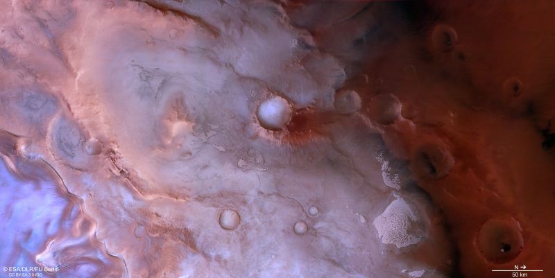 Red planet: Purple and bluish ground with ridges and some craters.