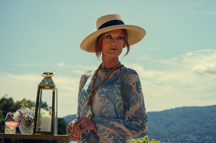 Joely Richardson in The Gentlemen, wearing a white hat and blue dress.