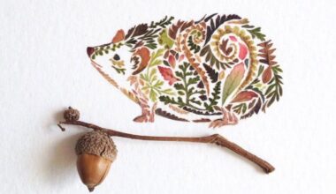 A hedgehog illustration made entirely from pressed autumn leaves and ferns in browns, ochres and greens, positioned beside a real acorn and oak twig.
