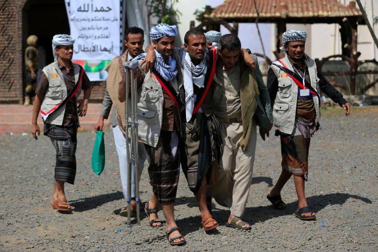 Yemeni prisoners loyal to the Houthi authorities help an injured comrade after being released on the west coast where they were being held by Yemen's Saudi-backed government forces, as they arrive in the capital Sanaa on September 12, 2026.