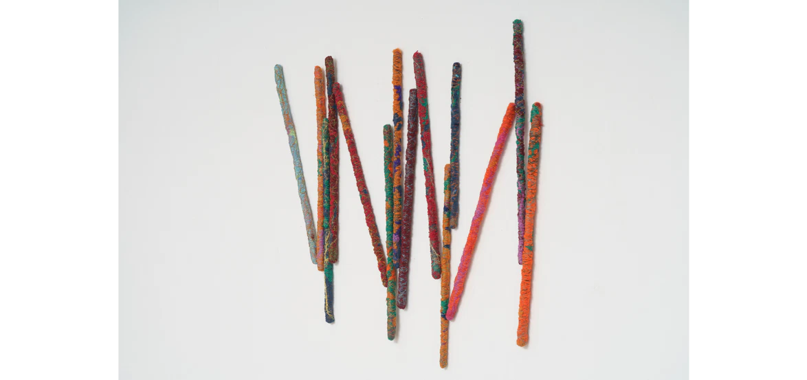 Colorful, textured sticks arranged randomly on a white background.