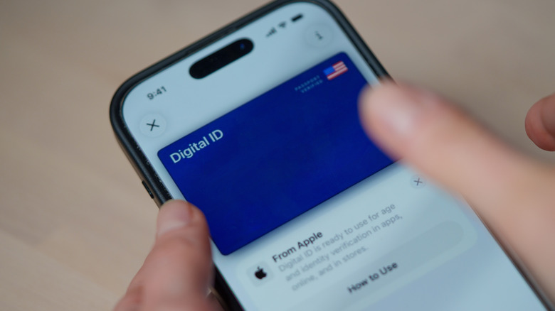 iPhone displaying a digital ID card in Apple Wallet as a finger taps the screen.