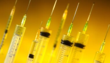 A bunch of hypodermic needles against a glowing yellow background.
