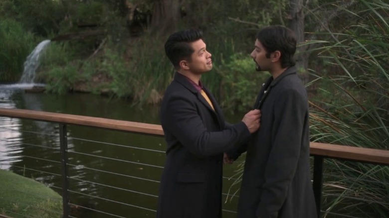 Henry holding Jorge's lapel while standing next to a guardrail on With Love S1E3