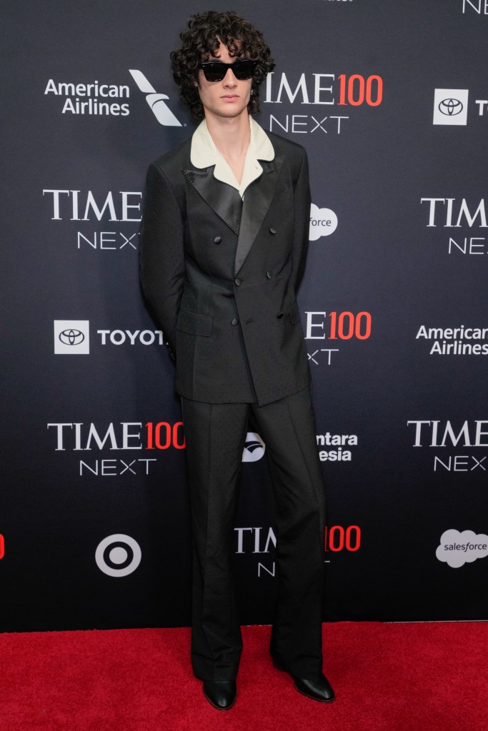 Sombr arrives at Time100 Next in a black suit with a white collared shirt and sunglasses.