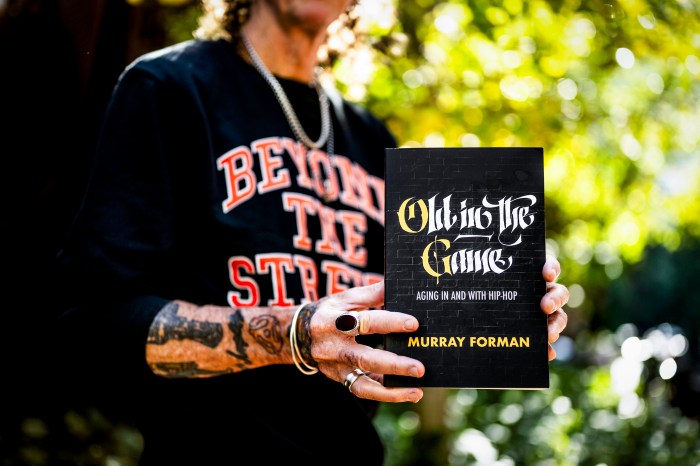 Murray Forman holds a print of his new book.