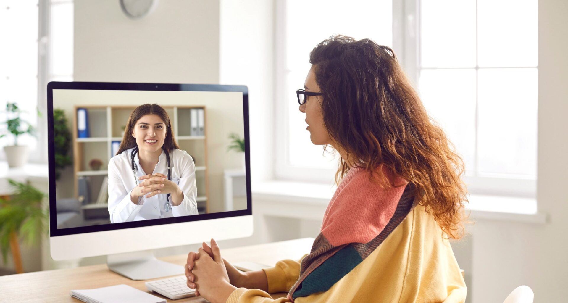 Sick woman listening recommendations and appointment having online video call with a female friendly smiling doctor using pc computer at home.