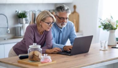 Couple on their laptop in their home kitchen.
