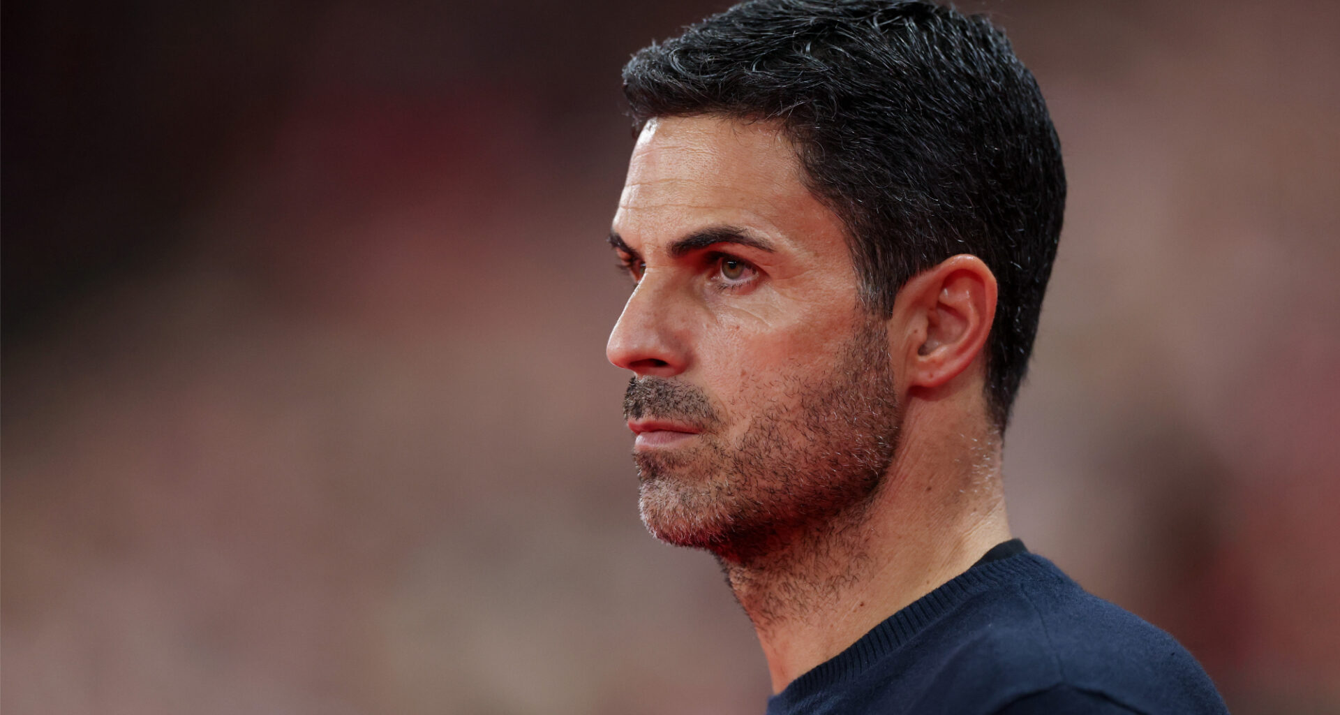 Side-on image of Arsenal manager Mikel Arteta looking onwards.