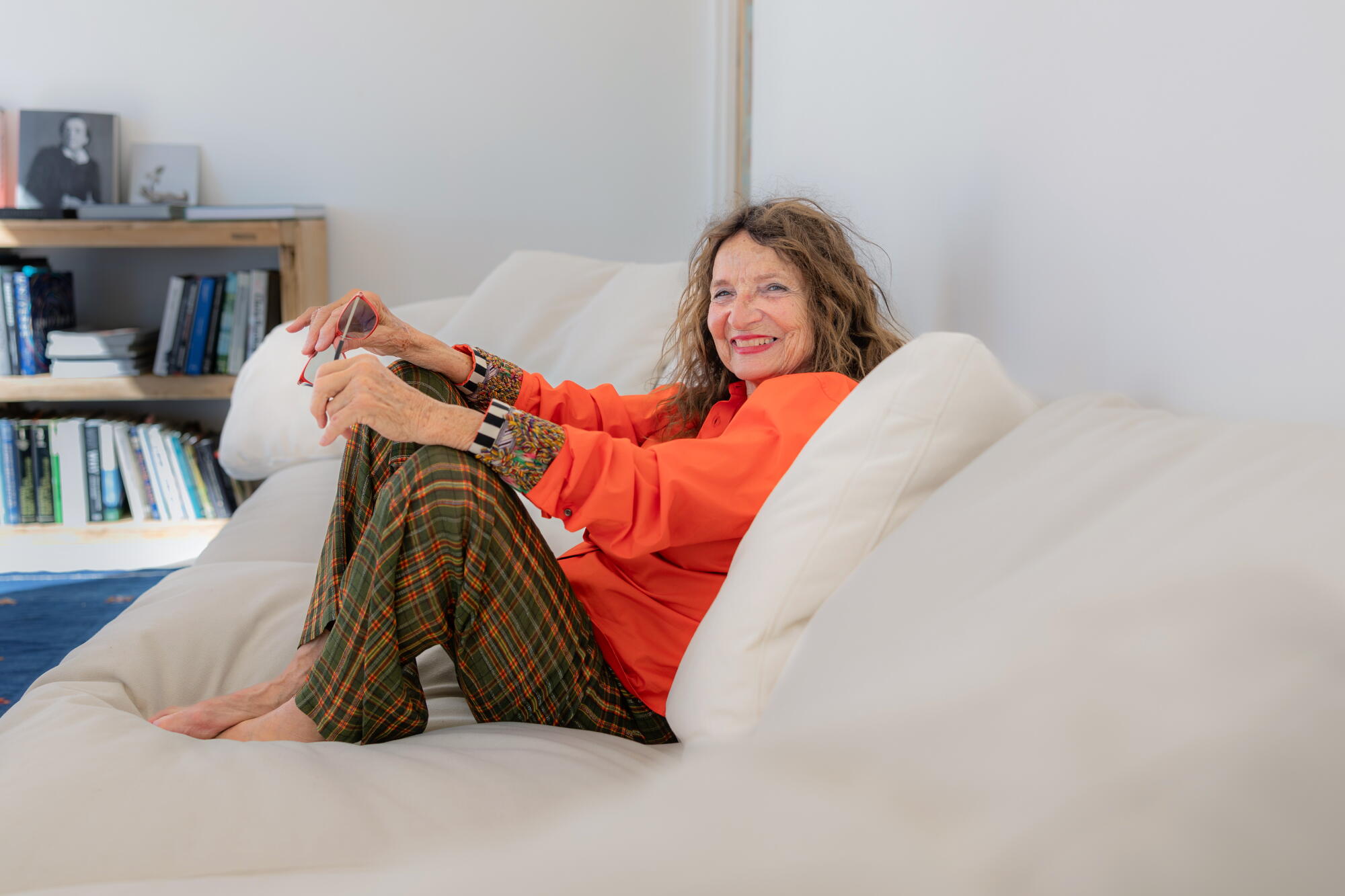  A woman smiles on a couch.