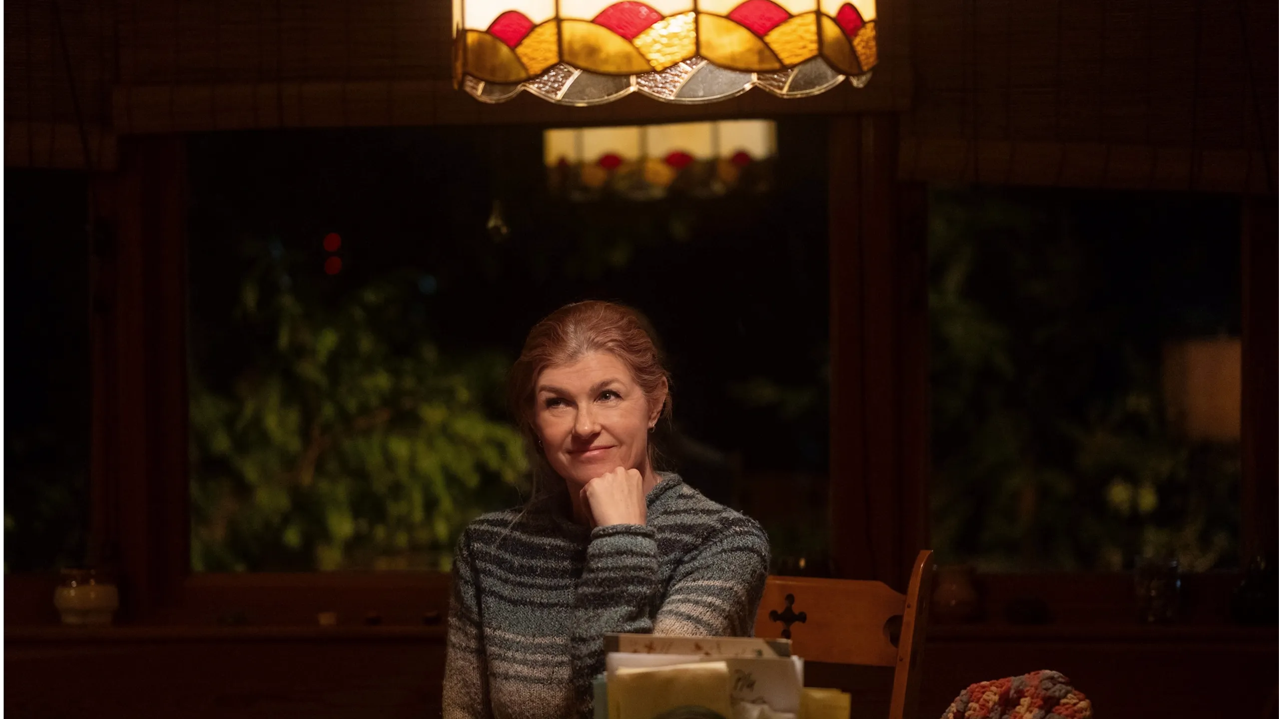 Ellen (Connie Britton) sitting at a table, smiling softly