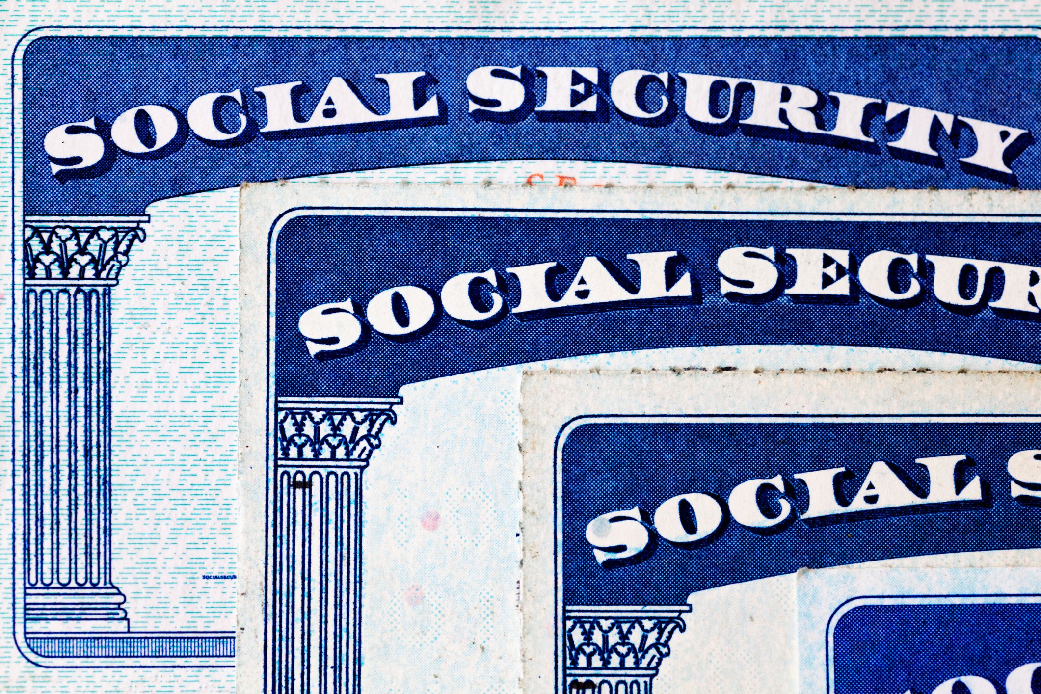 Close-up of overlapping vintage Social Security cards in blue and white