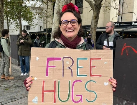 Jesse, 40, a charity worker from the north of Paris, grins and holds up a cardboard sign reading ‘Free Hugs’