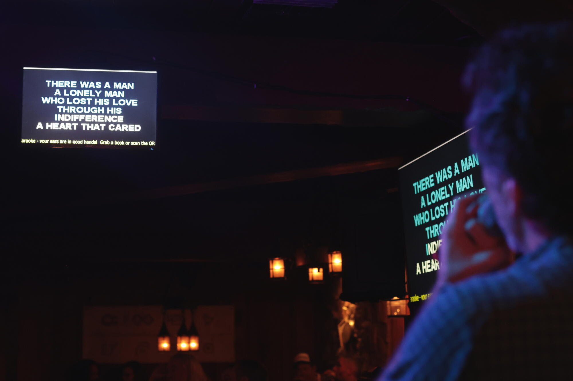 Lyrics for "Solitaire," a Neil Sedaka ballad, plays during a karaoke performance.