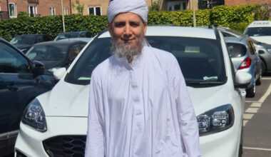 A man smiling wearing white